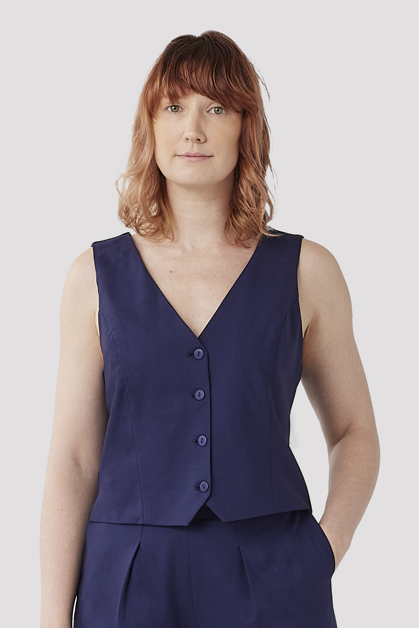 The Wool Vest by Aam is a chic, slightly cropped vest designed to flatter women with full hips and thighs. Featuring an elegant v-neck, tone-on-tone buttons and a slimming silhouette through the waist. Available in four colors, including the vibrant indigo shade shown in this photograph.