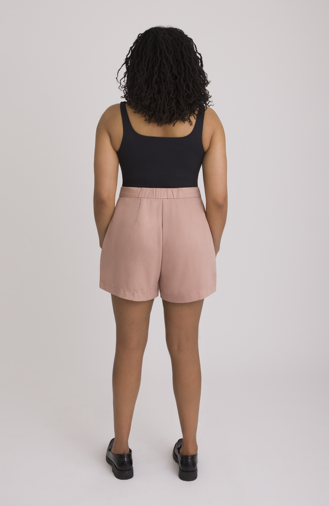 The Anywhere Short sits snug at the high waist with a roomy fit for full hips. Shown here is the back view in a gorgeous melon pink.