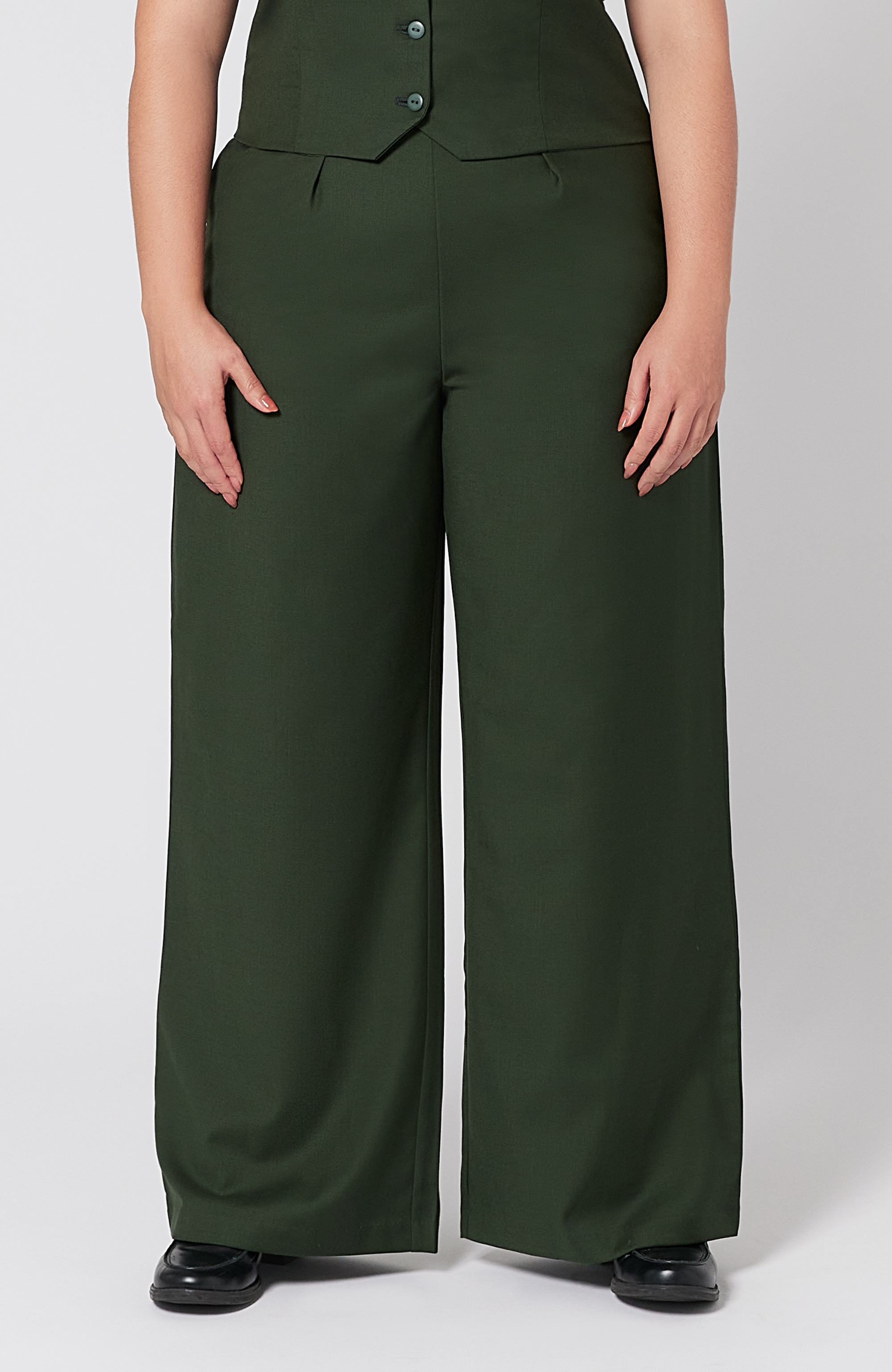 The Wool Wide Leg Pant by Aam The Label is designed for full hips and thighs. It sits high on the waist with a roomy fit for curvy hips. Made from a warm merino wool and fully lined with organic cotton. It is shown here in a gorgeous, deep green shade.