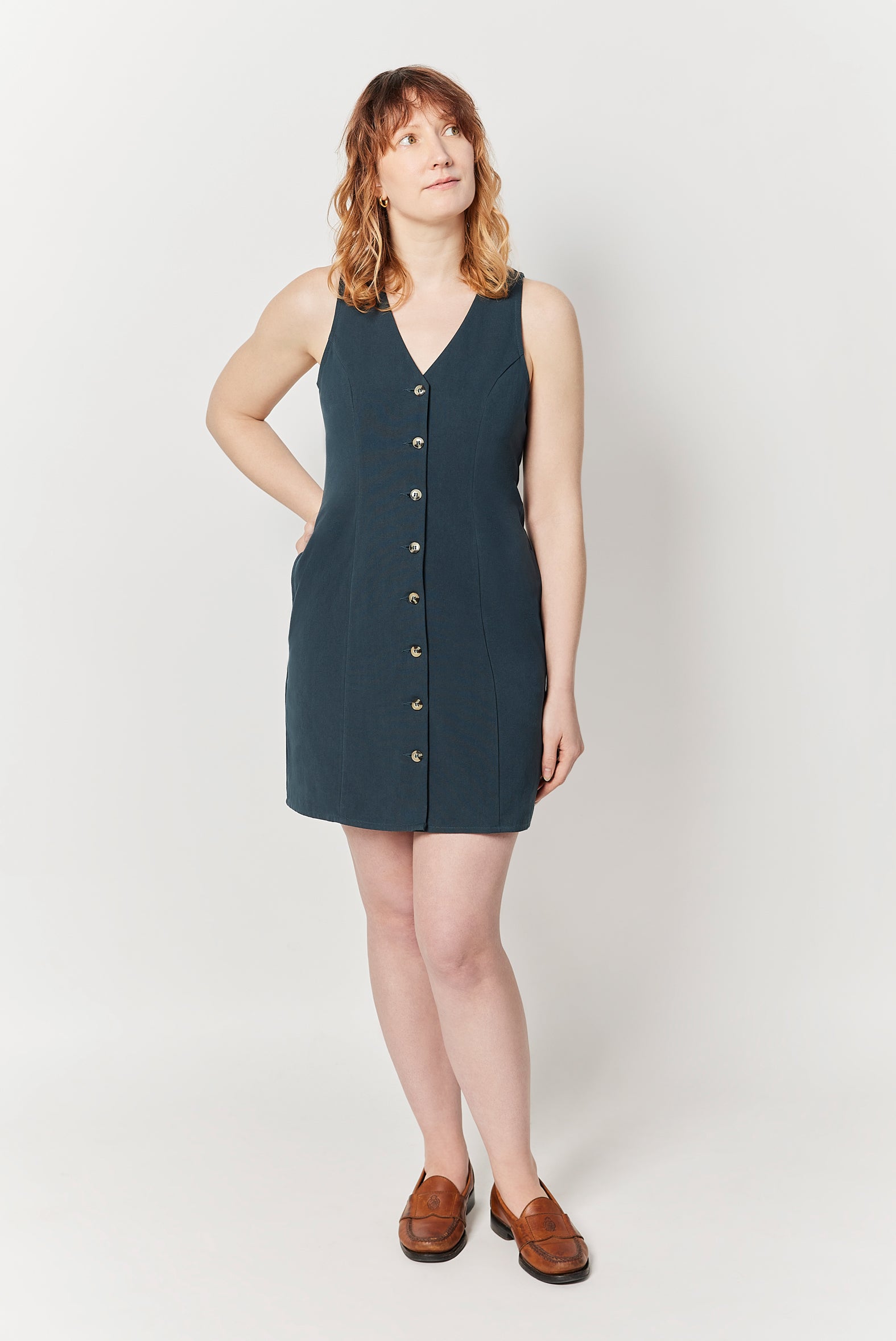 The Everywhere Dress is made for pear and hourglass shapes. Designed to slim through the waist with a roomy fit for full hips and thighs. It's mid-thigh length with a front button closure and is ethically made from 100% organic cotton. This is The Everywhere Dress in Deep Teal.