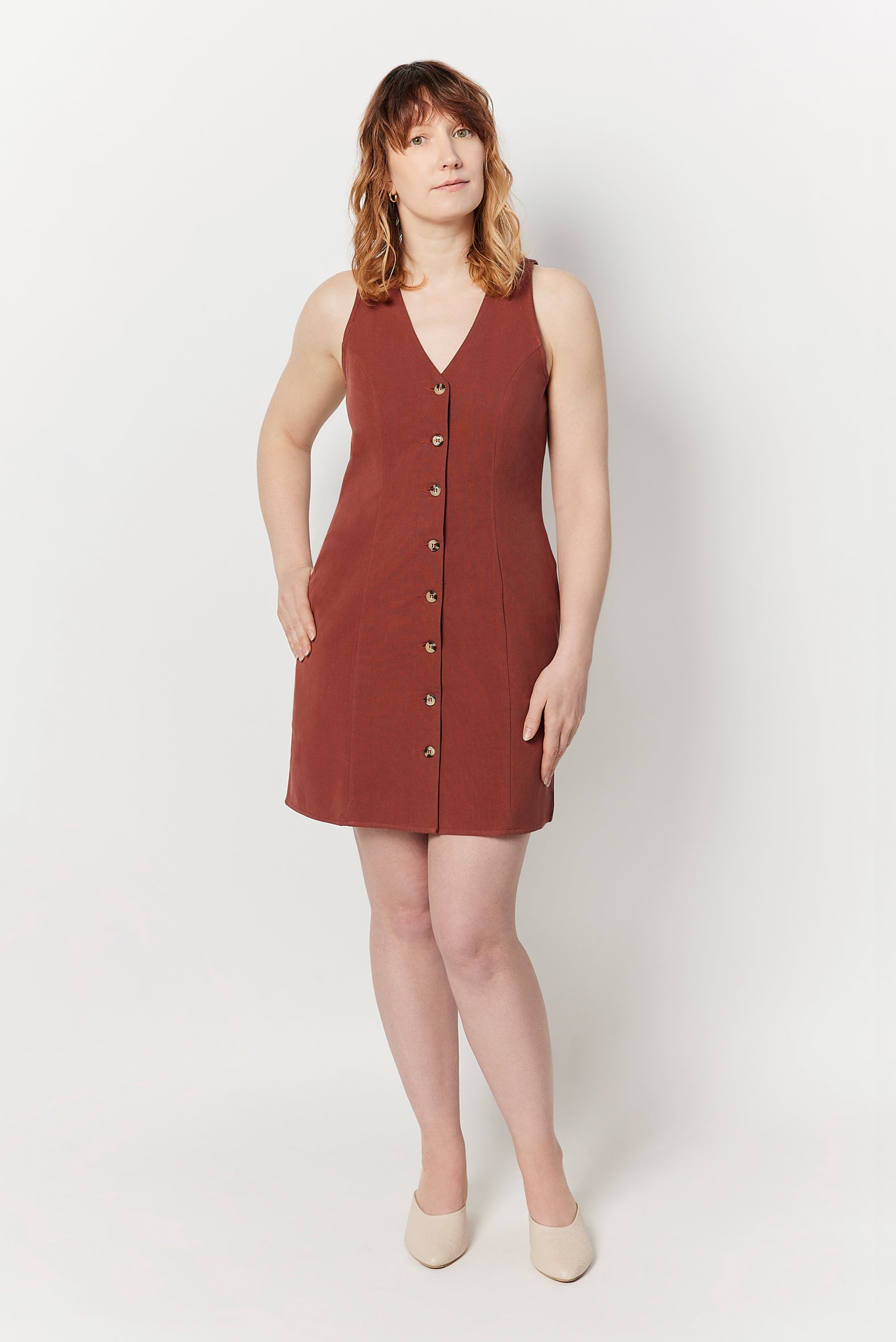 The Everywhere Dress is made for pear and hourglass shapes. Designed to slim through the waist with a roomy fit for full hips and thighs. It's mid-thigh length with a front button closure and is ethically made from 100% organic cotton. This is The Everywhere Dress in Rosewood.