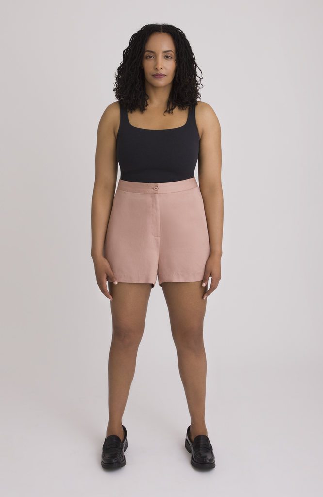The Anywhere Short is made for full hips and thighs. It is high waisted with a small back elastic for comfort and has a roomy fit through the seat for curvy bottom shapes. Shown here is the front view on the short in a gorgeous melon pink.