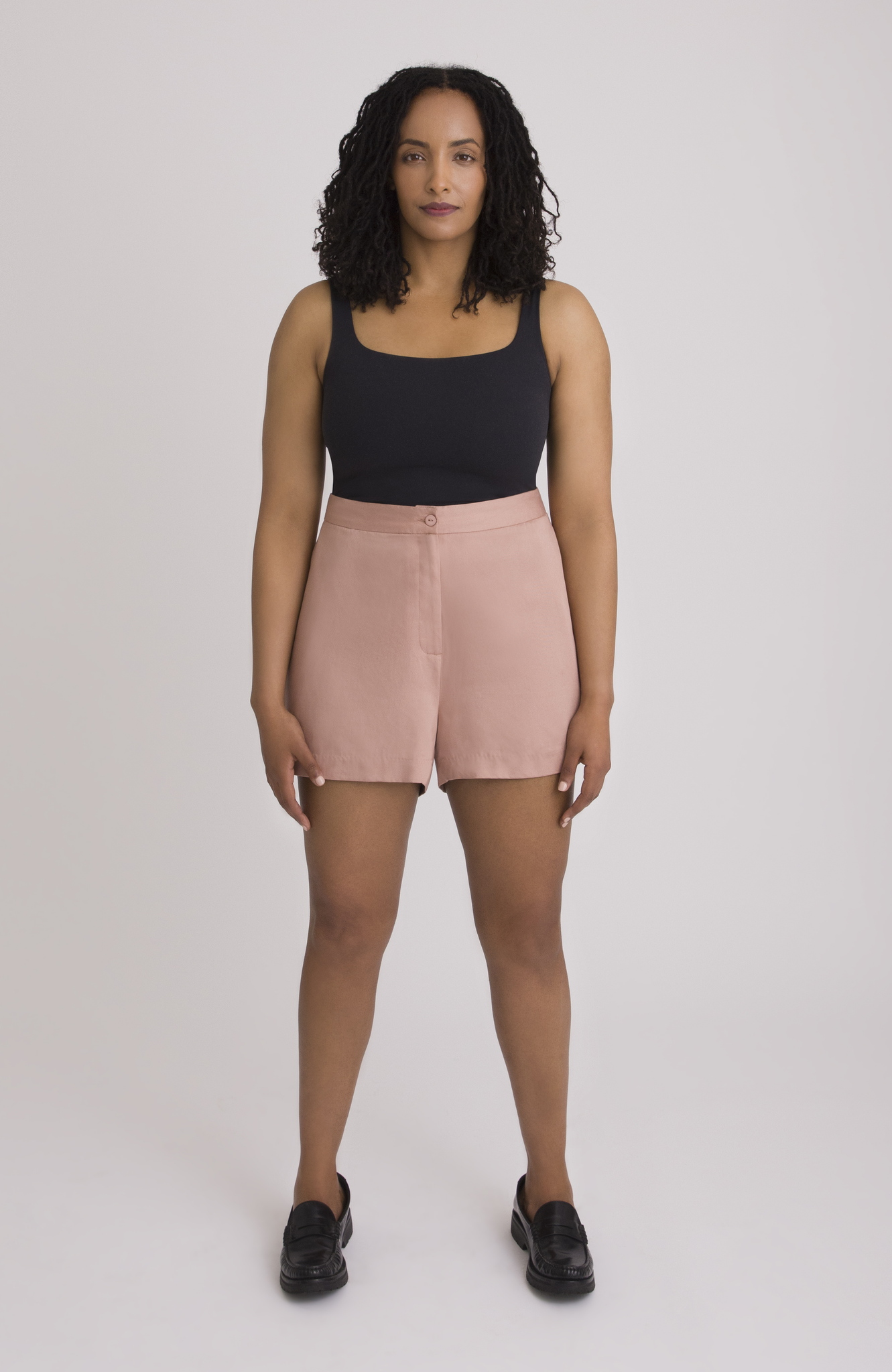 The Anywhere Short is made for full hips and thighs. It is high waisted with a small back elastic for comfort and has a roomy fit through the seat for curvy bottom shapes. Shown here is the front view on the short in a gorgeous melon pink.