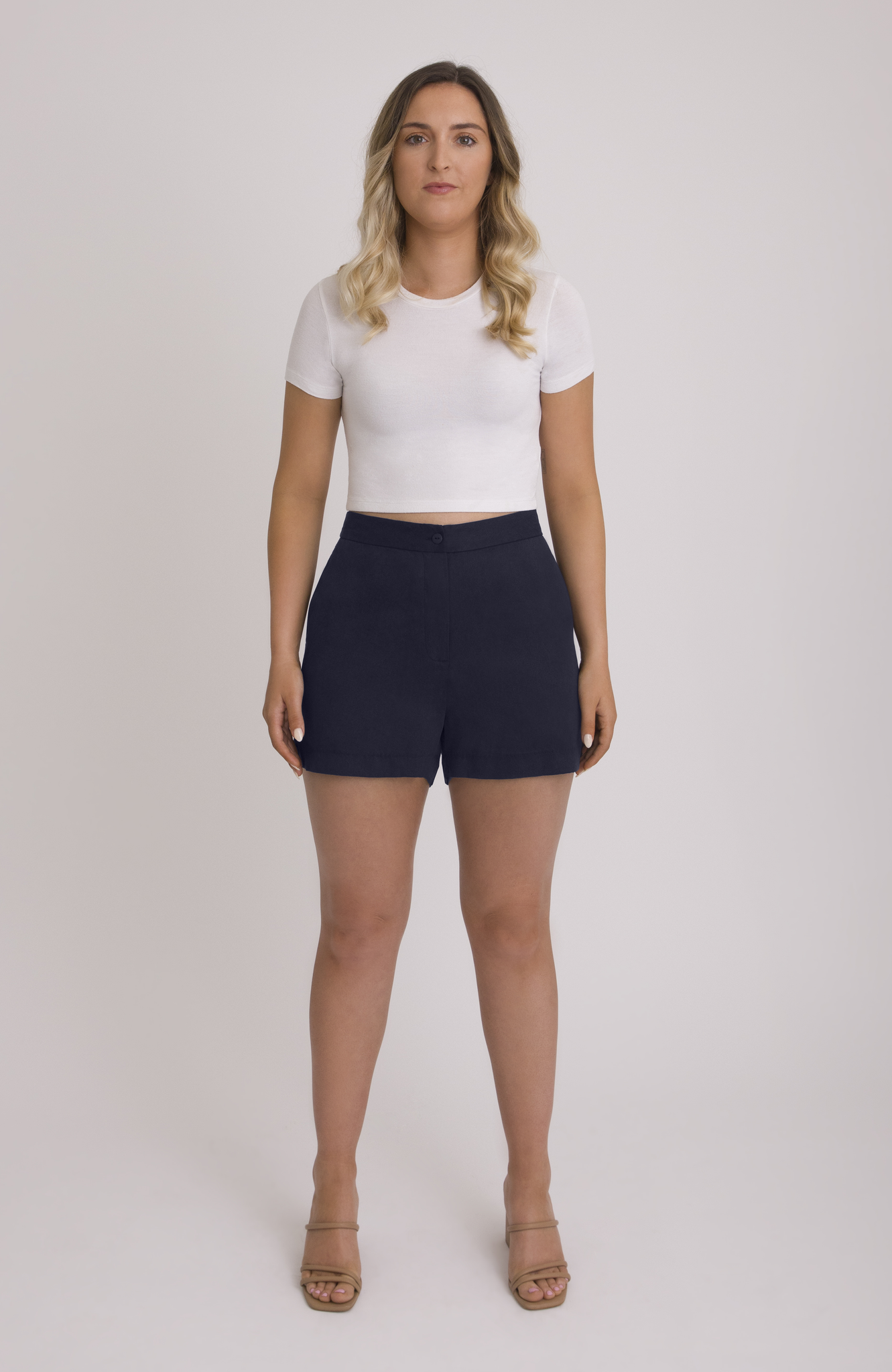 The Anywhere Short is made for full hips and thighs. It is high waisted with a small back elastic for comfort and has a roomy fit through the seat for curvy bottom shapes. Shown here is the front view on the short in classic navy.