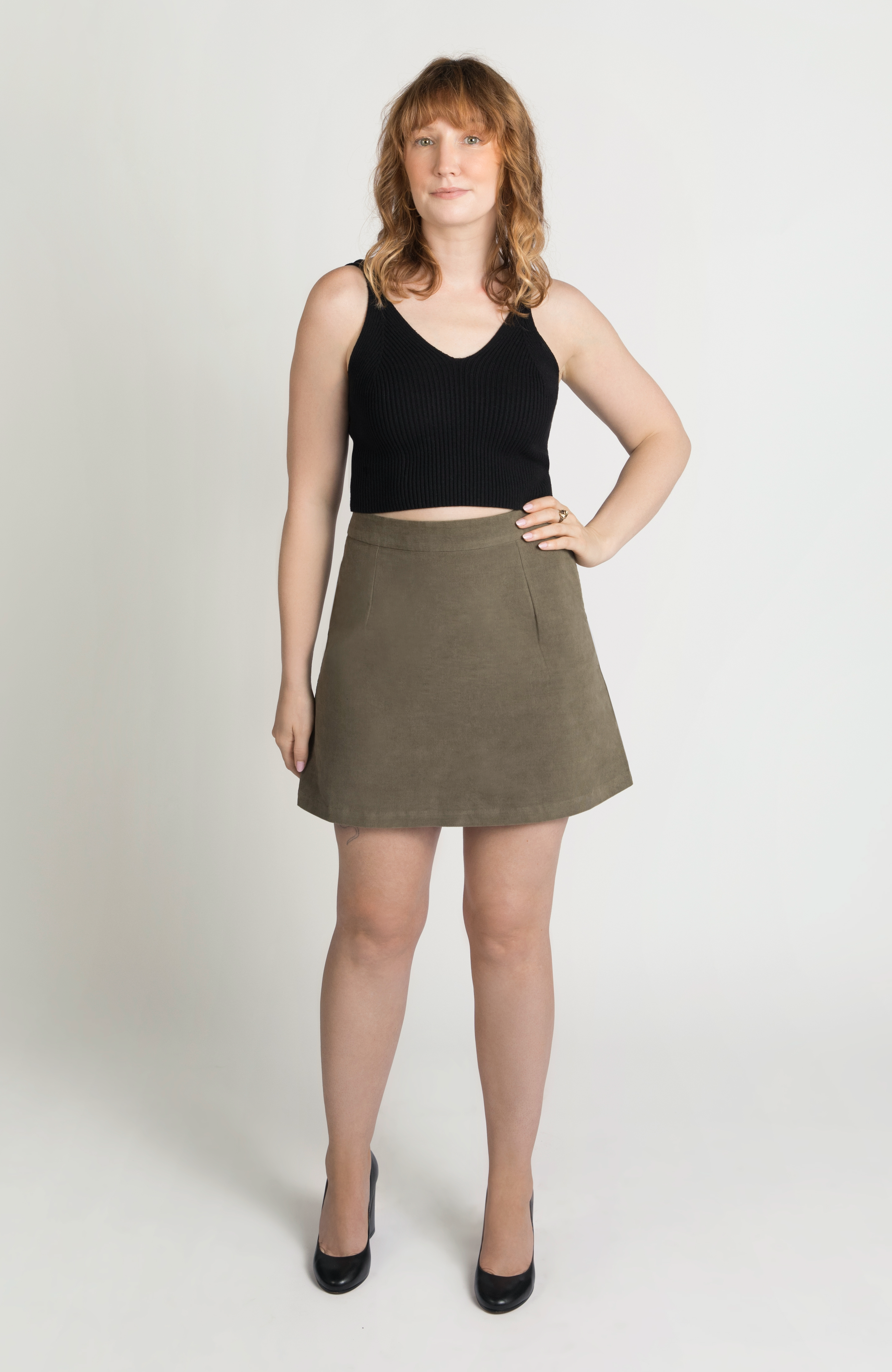 The Cord Mini Skirt by Aam The Label is designed to sit snug at the high waist with a roomy fit for full hips and thighs. Featuring a small, center back elastic for comfort fit at the waist, and hidden zipper closure for a seamless finish. Made from a soft 97% cotton corduroy with 3% stretch. Shown here is the full frontal view of the skirt in a gorgeous, neutral moss green shade.