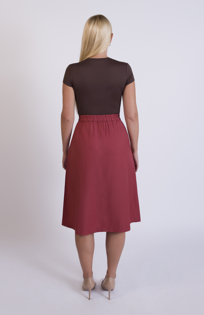 The Wool Midi Skirt by Aam The Label has a discreet back elastic that provides comfort at the waist and eliminates waist gaps. Shown here in Deep Salmon.
