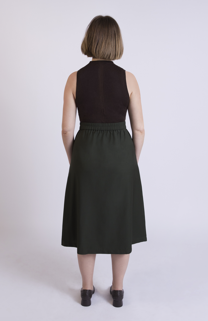 The Wool Midi Skirt by Aam The Label has a discreet back elastic that provides comfort at the waist and eliminates waist gaps. Shown here in Green.