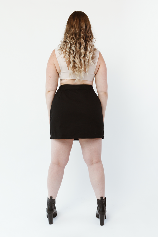The Mini Skirt by Aam is designed for women with full hips and thighs. Shown here is the back view of the black colored skirt on a model who is 5’5” and wearing a size Large. There are thoughtfully placed darts in the skirt to contour to a curvy seat shape, and the length is perfect for taking you from day to night. The fabric - a 100% organic cotton - also has the right amount of structure to hold you in and provide a flattering shape.