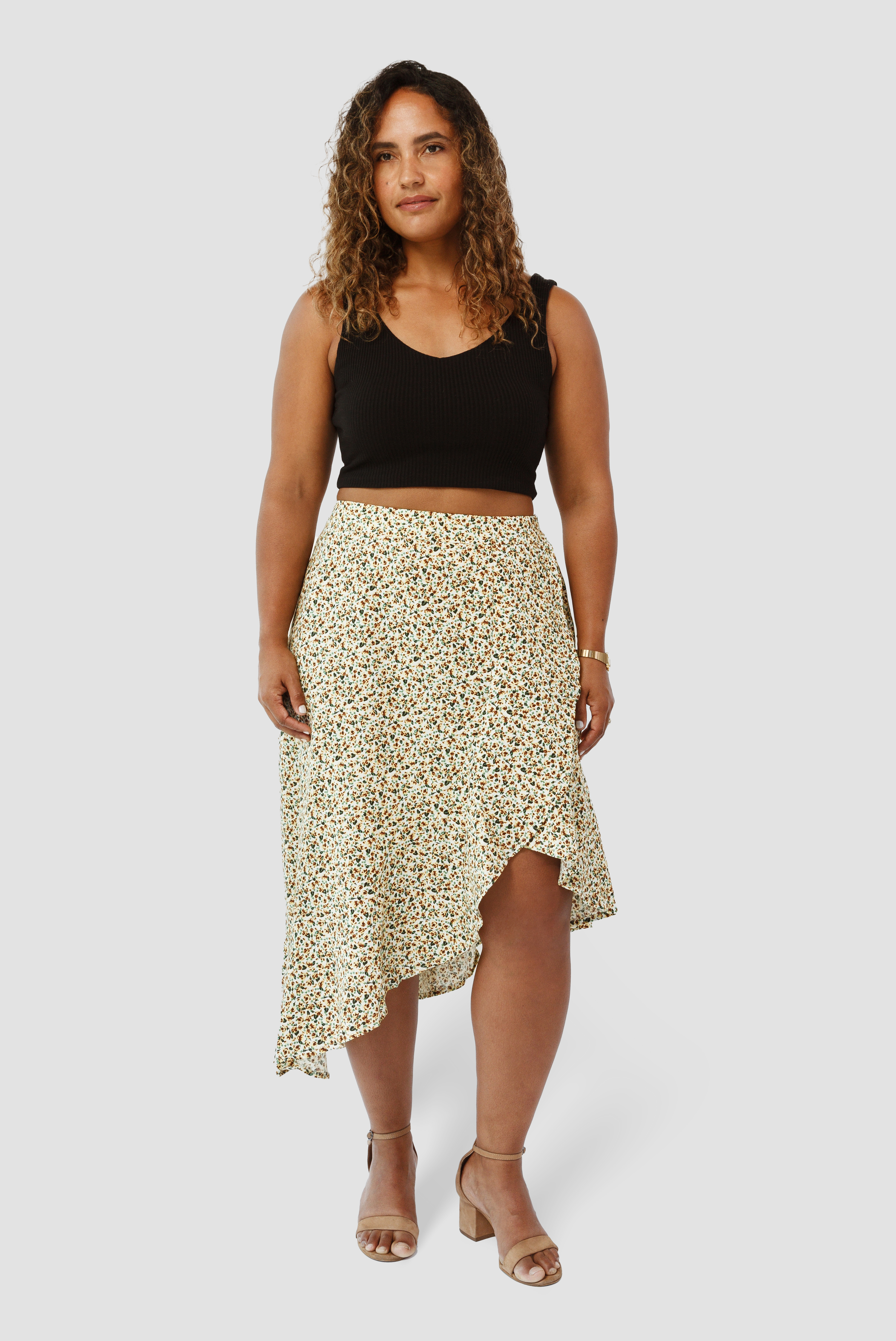 The Cascade Skirt by Aam is a universally flattering midi skirt. It sits high at the waist with more room for full hips and thighs. Shown here is the front view on a model who is 5'3