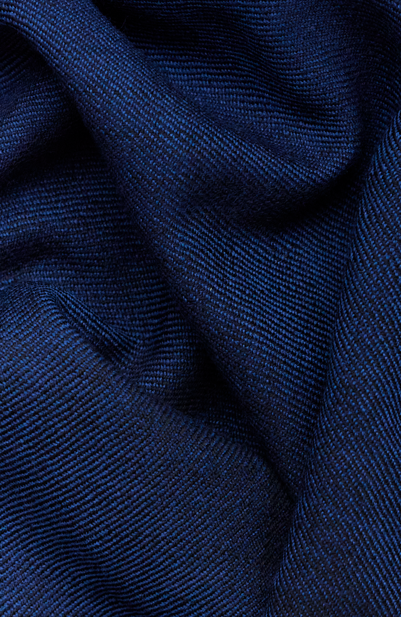 The Aurora Wrap has been handwoven by artisans and is reversible. The texture and detail in this scarf make it beautiful and soft to the touch. Here it is shown in the midnight hue.