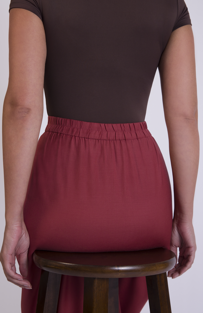 Designed with a waist-to-hip ratio for pear and hourglass shapes, the skirt sits snug at the high waist with plenty of room for your hips. There are no waist gaps. The Wool Midi Skirt is shown here in Deep Salmon.