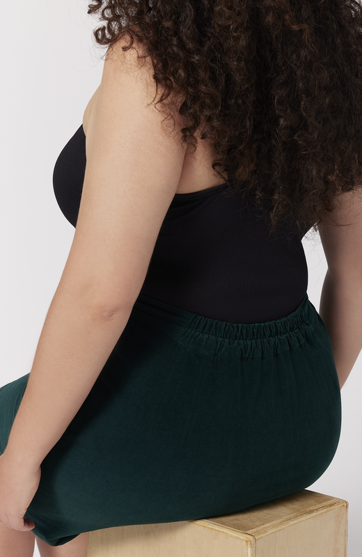 The Cord Mini skirt has a small back elastic for that "just right" fit at the waist. There are no waist gaps. Shown here in a deep, forest green shade.