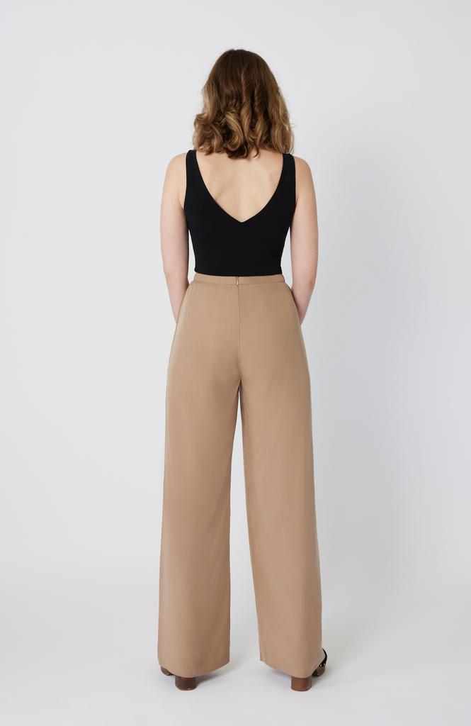 The Tall Wide Leg Pant sits snug at the high waist with a roomy fit through the hips and thighs. It features a long, hidden back zipper for ease of wear and a snatched fit through the waist, completely eliminating waist gaps. It’s shown here in a desert beige color.