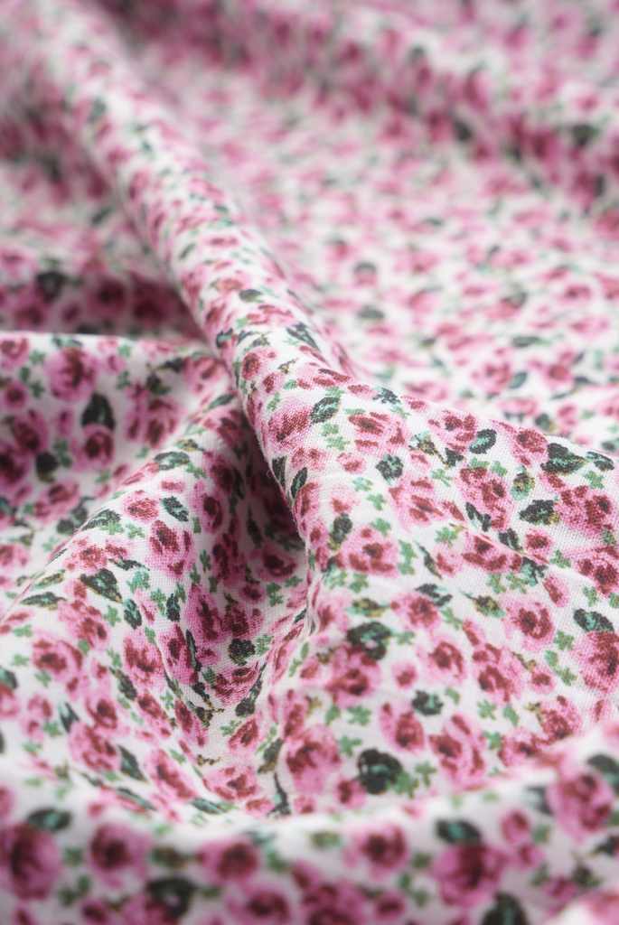 This is a close-up photo of the fabric of The Cascade Skirt by Aam The Label. It is made of a luxurious cotton-linen blend, is 100% machine washable, and has a beautiful pastel pink floral print.