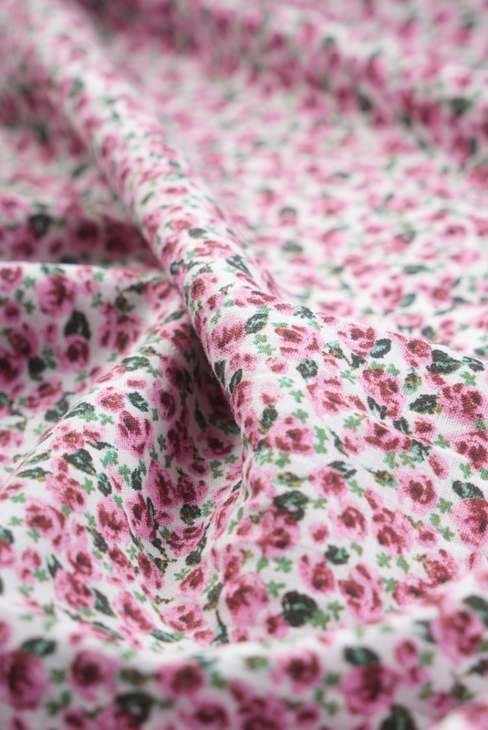This is a close-up photo of the fabric of The Cascade Skirt. It is made of a luxurious cotton-linen blend, is 100% machine washable, and has a beautiful pastel pink floral print.