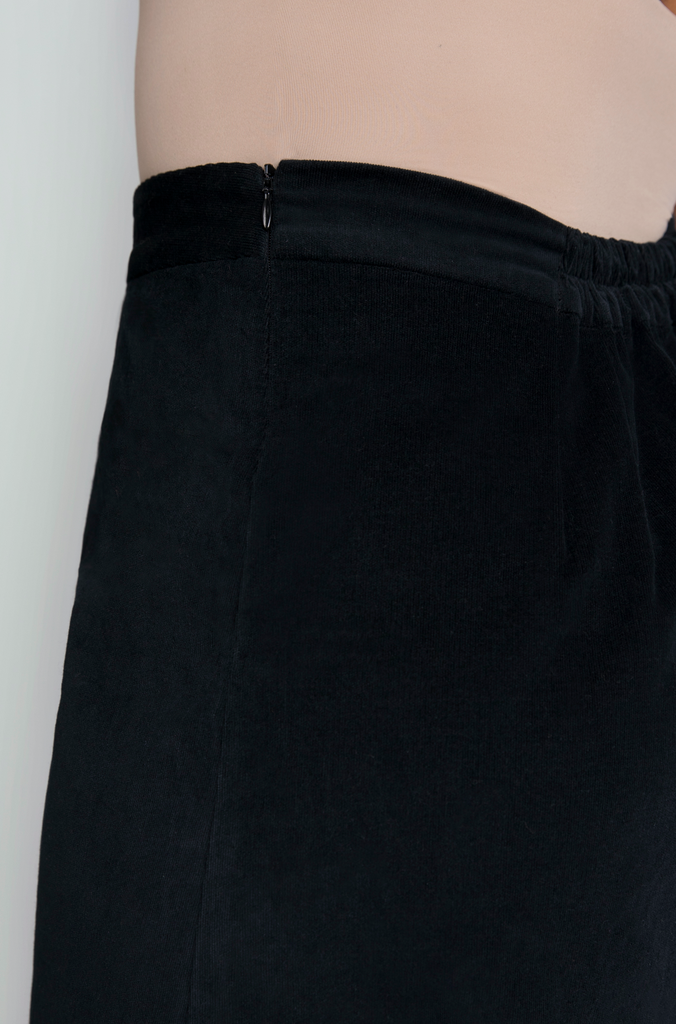 The skirt features hidden zipper closure for a seamless finish, shown here in classic black.
