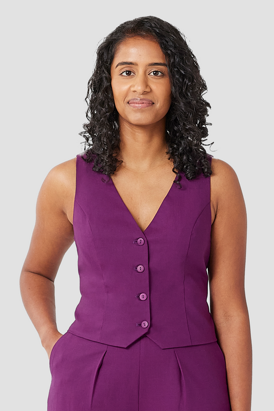 The Wool Vest by Aam is a chic, cropped vest that pairs perfectly with high waisted trousers. The vest is made from a warm, 96% wool with 4% elastane and is fully lined with organic cotton for a smooth finish on the skin. Shown here is a close-up of the vest in a striking plum color.