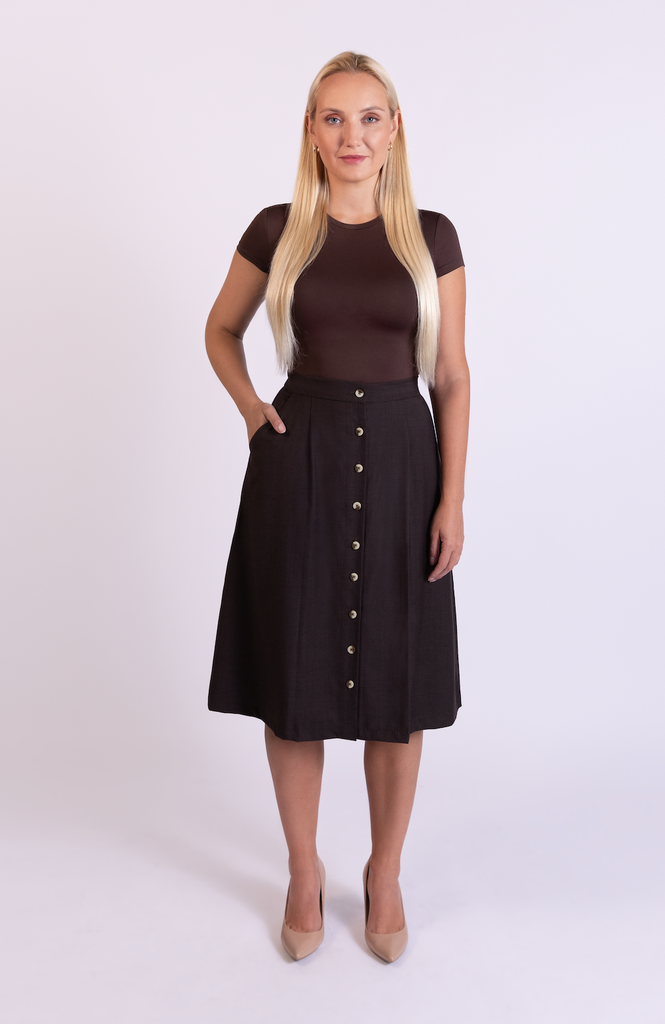 The Wool Midi Skirt is a gorgeous A-line skirt that sits snug at the high waist with a loose, flowy drape through the seat, comfortably accommodating full hips and thighs. It has a center button closure and two thin pleats for movement. Shown here in a gorgeous Cocoa Plaid print.