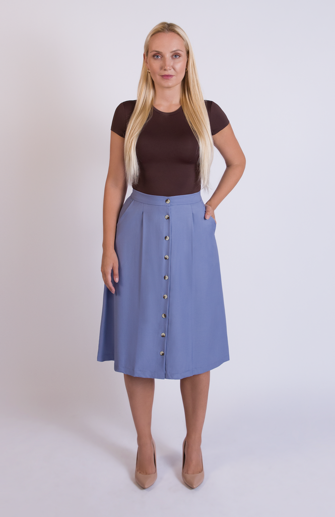 The Wool Midi Skirt is a gorgeous A-line skirt that sits snug at the high waist with a loose, flowy drape through the seat, comfortably accommodating full hips and thighs. It has a center button closure and two thin pleats for movement. Shown here in a gorgeous Sky blue.