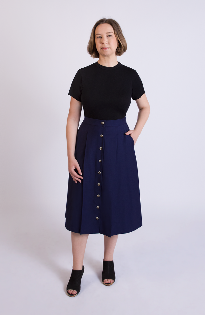 The Wool Midi Skirt is a gorgeous A-line skirt that sits snug at the high waist with a loose, flowy drape through the seat, comfortably accommodating full hips and thighs. It has a center button closure and two thin pleats for movement. Shown here in classic Navy blue.
