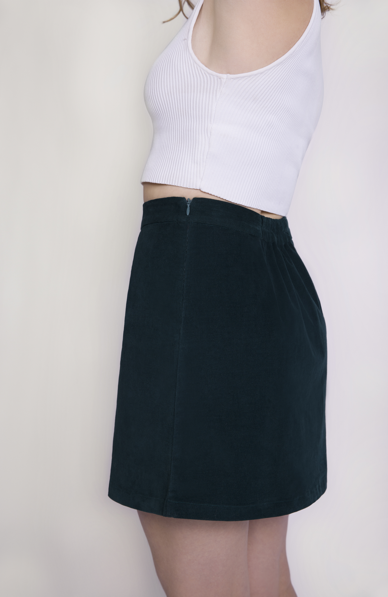 The skirt features hidden zipper closure for a seamless finish, shown here in a rich, forest green shade.